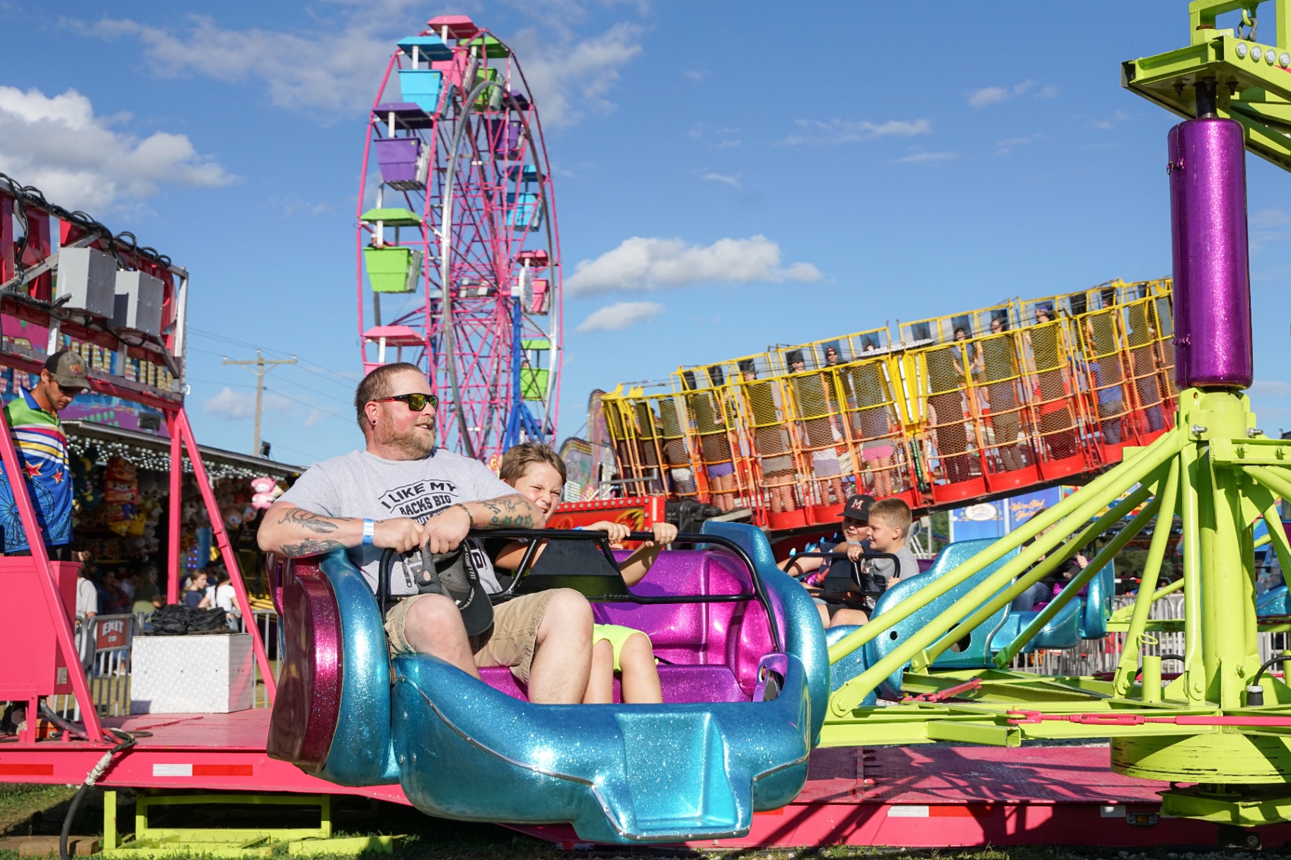 Carnival midway rides and games lit up at dusk