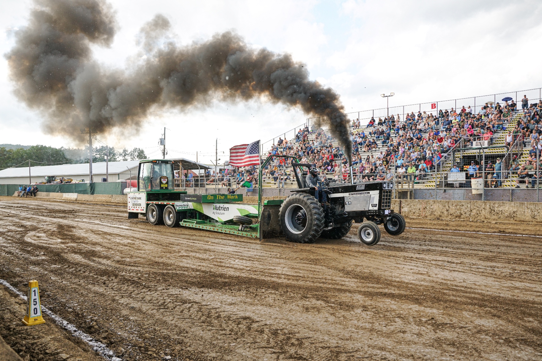Antique tractor pulling a sled down the grandstand track
